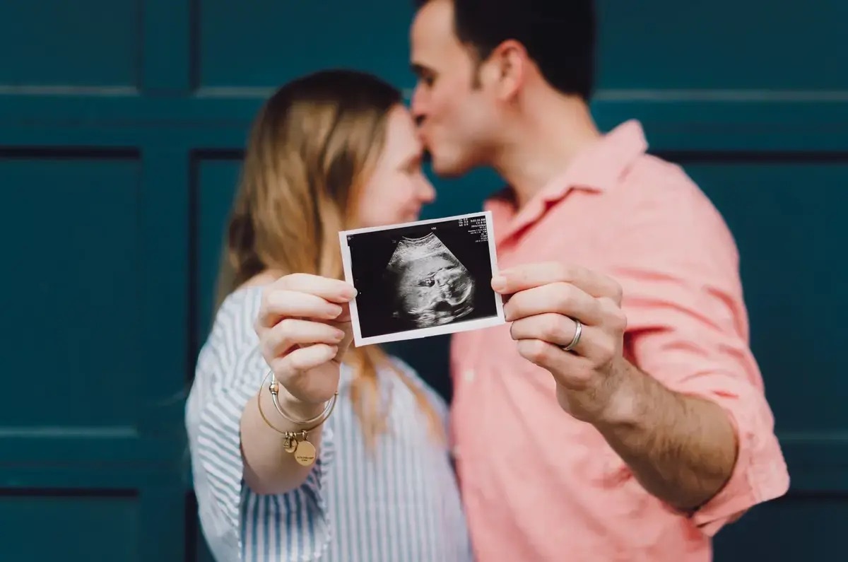 Expecting parents showing a scan of their upcoming baby